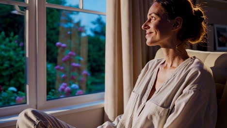 woman relaxing by the window at sunset
