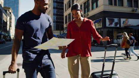 couple navigating a city street with a map and luggage