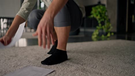 person kneeling on carpet picking up papers