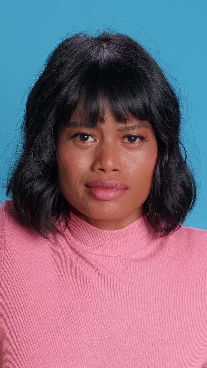 Sad and disappointed southeast asian woman sighing and looking upset on a solid