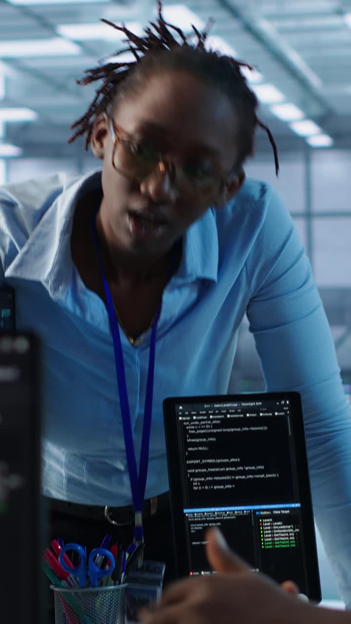 Software Engineers Discussing Code on Laptop in Server Room