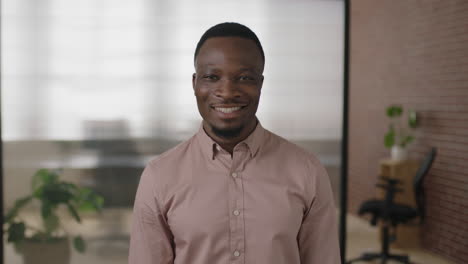 Retrato-De-Un-Joven-Hombre-De-Negocios-Afroamericano-Sonriendo-Disfrutando-De-Un-Exitoso-Inicio-De-Negocios-Empresario-Confiado-En-Un-Moderno-Espacio-De-Trabajo-De-Oficina