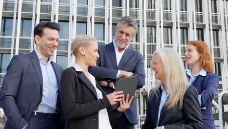 diverse business professionals collaborating outdoors with a tablet