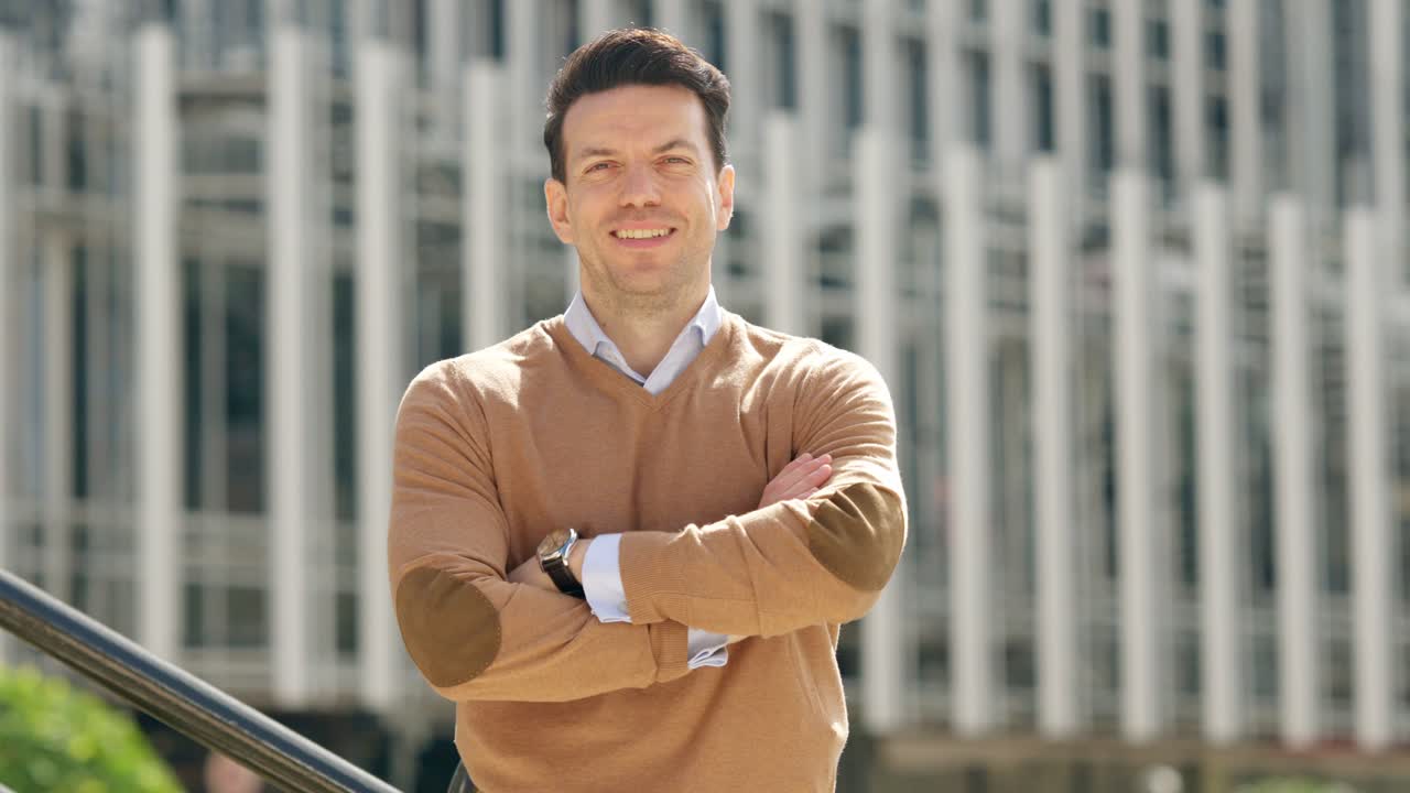 A man smiling confidently in front of a modern building