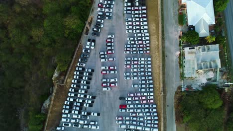 cars parked at harbor port ready for transport export import on barge ship, aerial top down pan