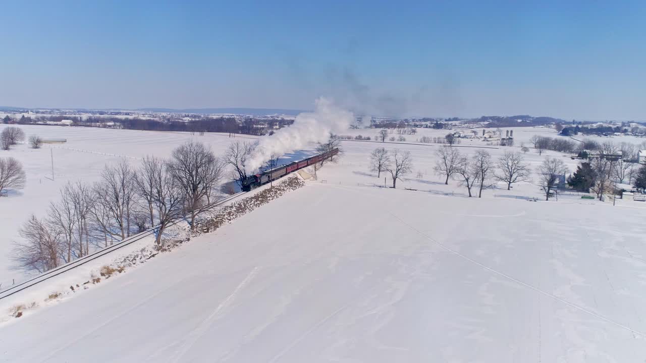 늦은 오후 황금시간대에 객차를 끌고 연기와 증기를 내뿜는 골동품 증기 기관차의 공중 전망