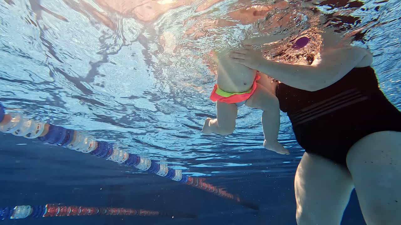 엄마 가 아기 에게 물  에서 수영 하는 법 을 가르치는 것