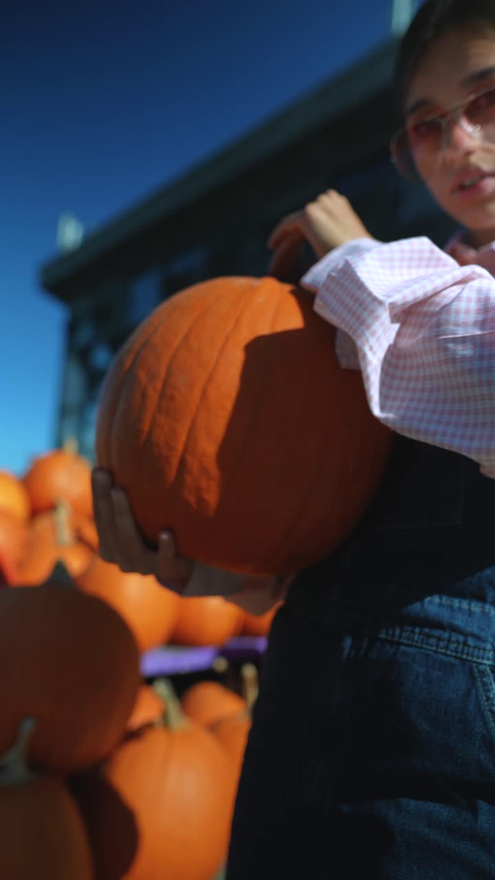 mujer joven sosteniendo una gran calabaza