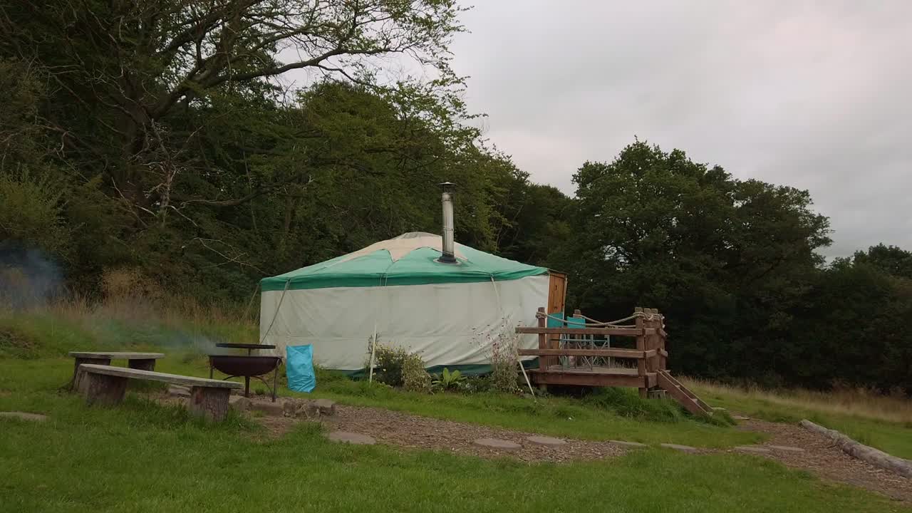Yurt camping in woodland while a bbq burns