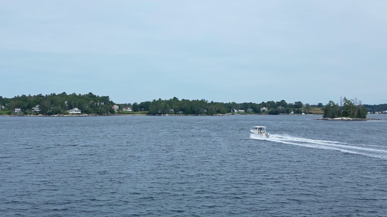 лодка сису 22 быстро проходит через гавань бут-бей, штат мэн, легко пересекая воду, оставляя след в оживленной гавани.