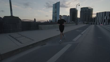 an athlete goes running, jogging on a bridge on the main in frankfurt