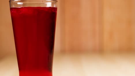 a glass filled with red soft drink