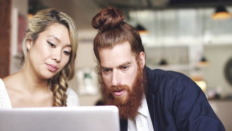 pareja joven usando una tableta digital en una cafetería