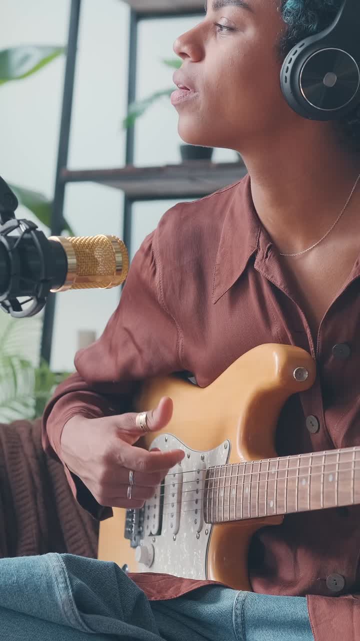 Young african american woman singer plays guitar and sings into microphone