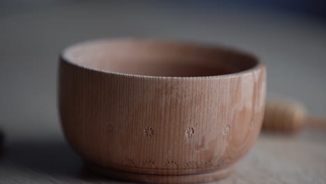 du miel dans un bol en bois profond, une assiette en bois rustique. la cuillère en bois coule lentement.