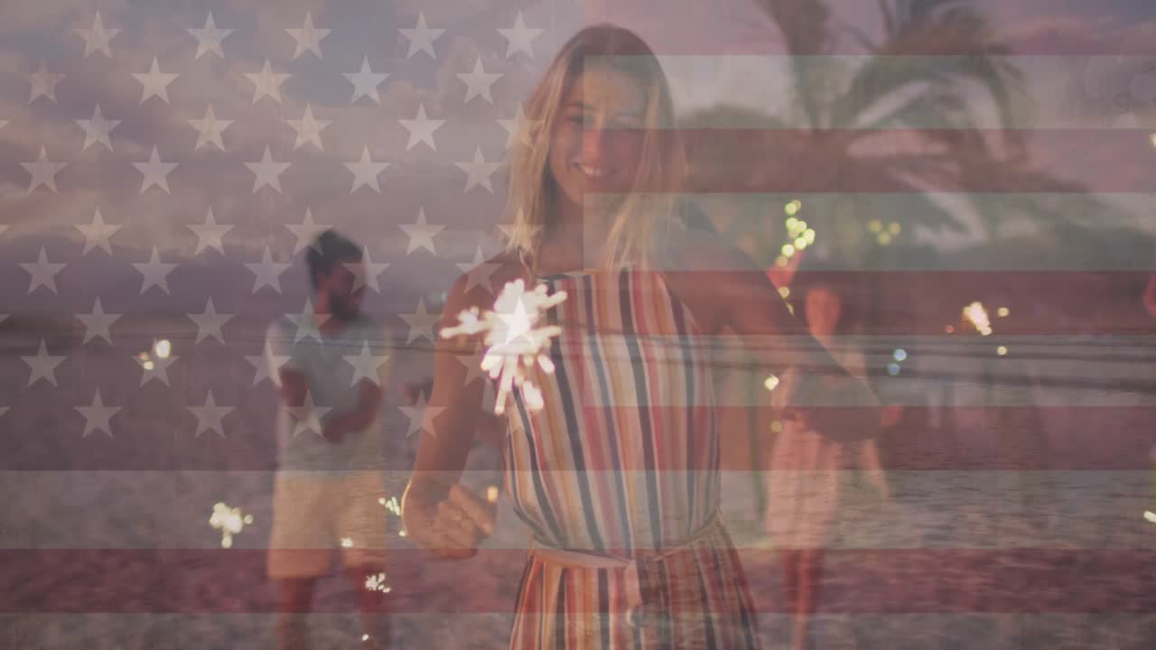 Animación de la bandera de los Estados Unidos de América sobre felices amigos diversos con bengalas en la playa.