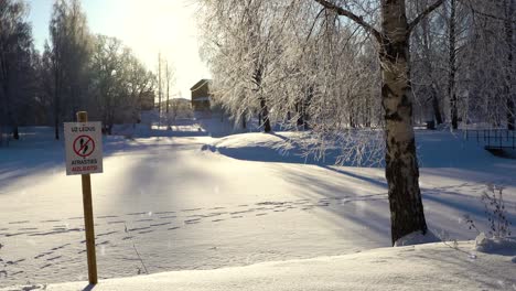 el cartel prohíbe caminar por el lago congelado, pero las pistas de la gente están en la nieve, vista a la derecha