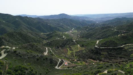 Lush-green-cyprus-mountain-landscape-with-winding-roads-and-scattered-houses,-aerial-view