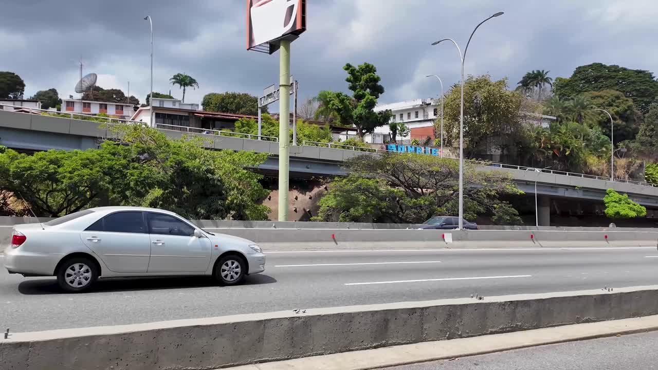 Traffic on the Prados del Este highway showing the VAO structure, peak hours signage