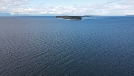 Aerial-wide-shot-showing-Savary-Island-in-Canada-during-sunny-day-with-clouds-and-blue-water-of-Ocean