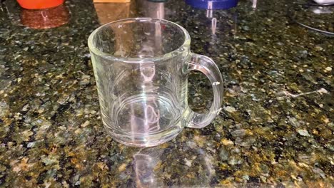 coffee mug, ready for coffee or tea. clear cup on counter. coffee or tea?