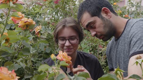 young girl and man examines flowers with a magnifying glass