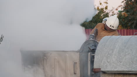 firefighter puts out a fire near garbage bins after a riot