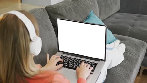 chica caucásica en una computadora portátil aprendiendo en línea con pantalla en blanco