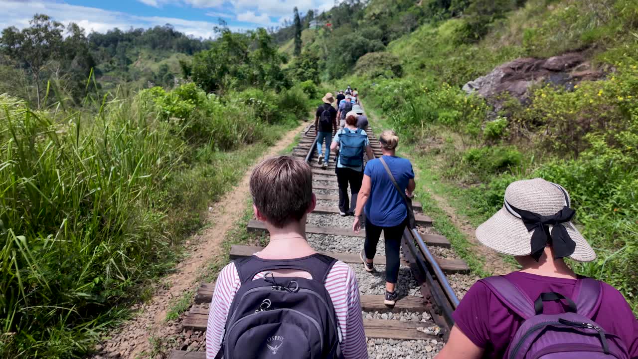Group of Hikers Walking Uphill on Train Tracks in Sri Lanka