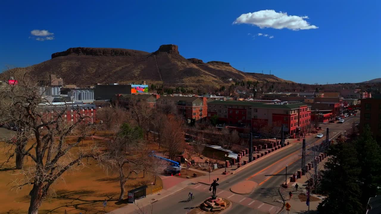 Beautiful winter day sunny clouds historic downtown Golden Colorado aerial drone Coors Beer Factory North Table Mountain Mesa Clear Creek River park Golden Gate Canyon blue sky upwards motion
