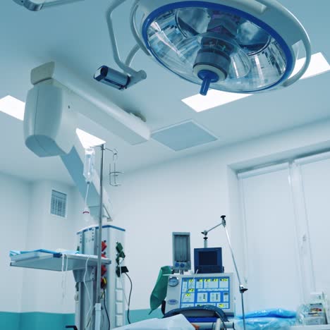 advanced equipment in the operating room. contemporary lamp above the surgery bed in the light operating theatre. empty room for plastic surgery.