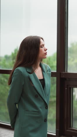 woman leader strolls along expansive windows. lady brows furrowed in contemplation over dwindling client contracts. financial uncertainty about future