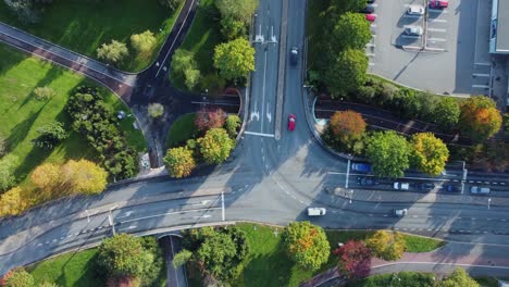 Overhead-aerial-looks-down-onto-city-traffic-driving-at-T-intersection