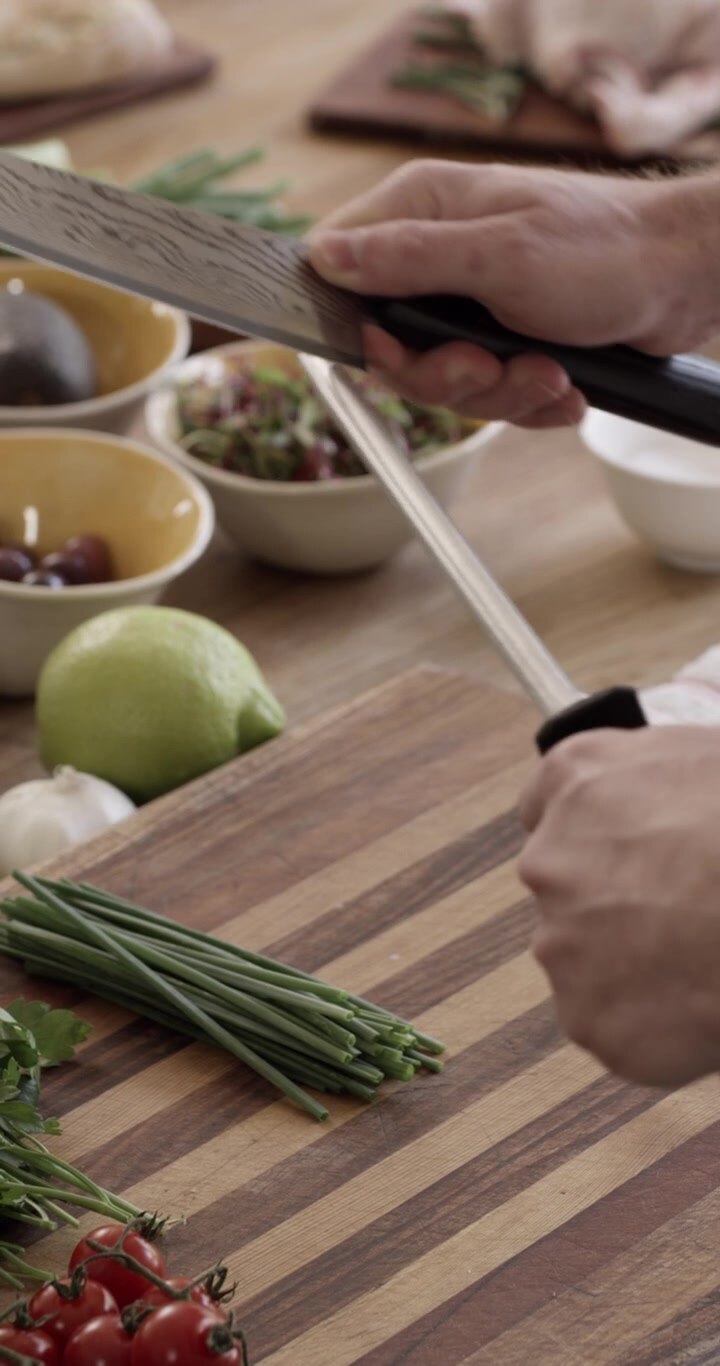Chef Sharpening a Kitchen Knife on a Honing Steel