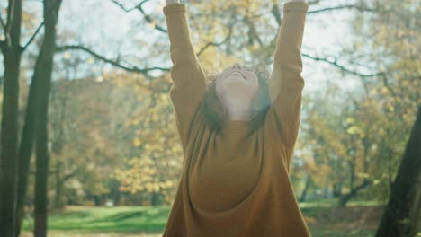 caucasian ginger woman throw up autumn leaves and enjoying the weather.