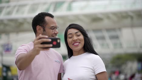 smiling couple recording video message with smartphone