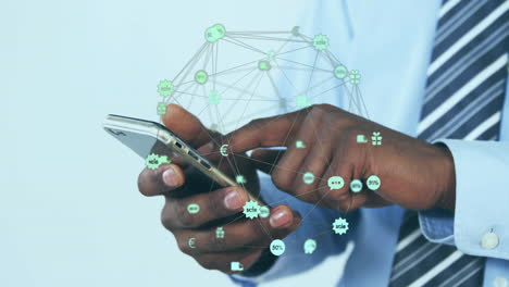 animation of globe of network of connections with icons over afrcian american man using smartphone