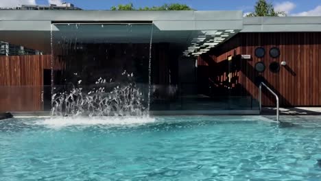 swimming pool with a waterfall flowing into it, slow motion video sequence