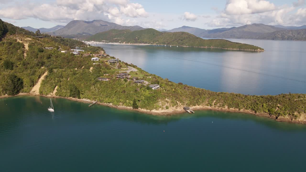estrecha península con varias casas de vacaciones que llegan a los fiordos de marlborough sound bajo el sol dorado
