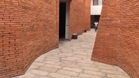 explore the intricate curves of red brick walls and paved pathways in an urban architectural space.