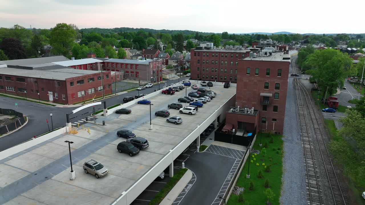 Aerial flyover of parking lot. Parking garage provides space to park for people living in condos downtown. 55+ community in America.