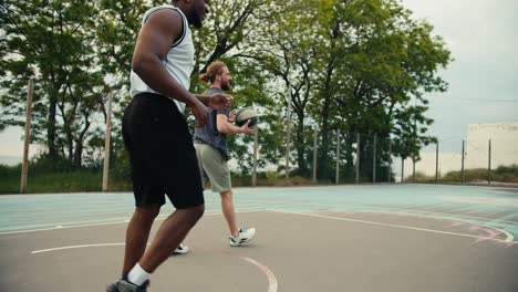 friends play amateur basketball on the basketball court. a black person dribbles a black and white ball and perfectly throws the ball into the ring