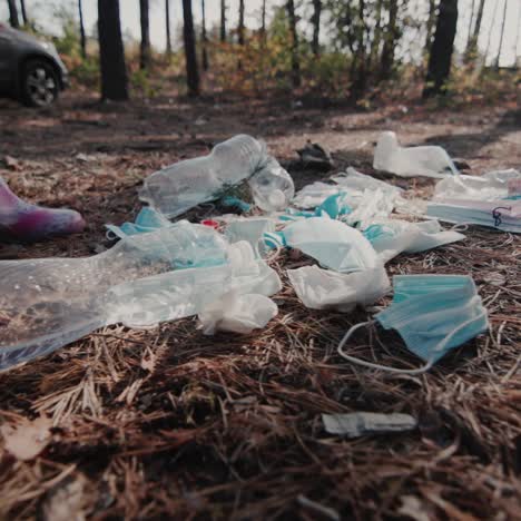 a child in a boots walks through a pile of garbage in the forest