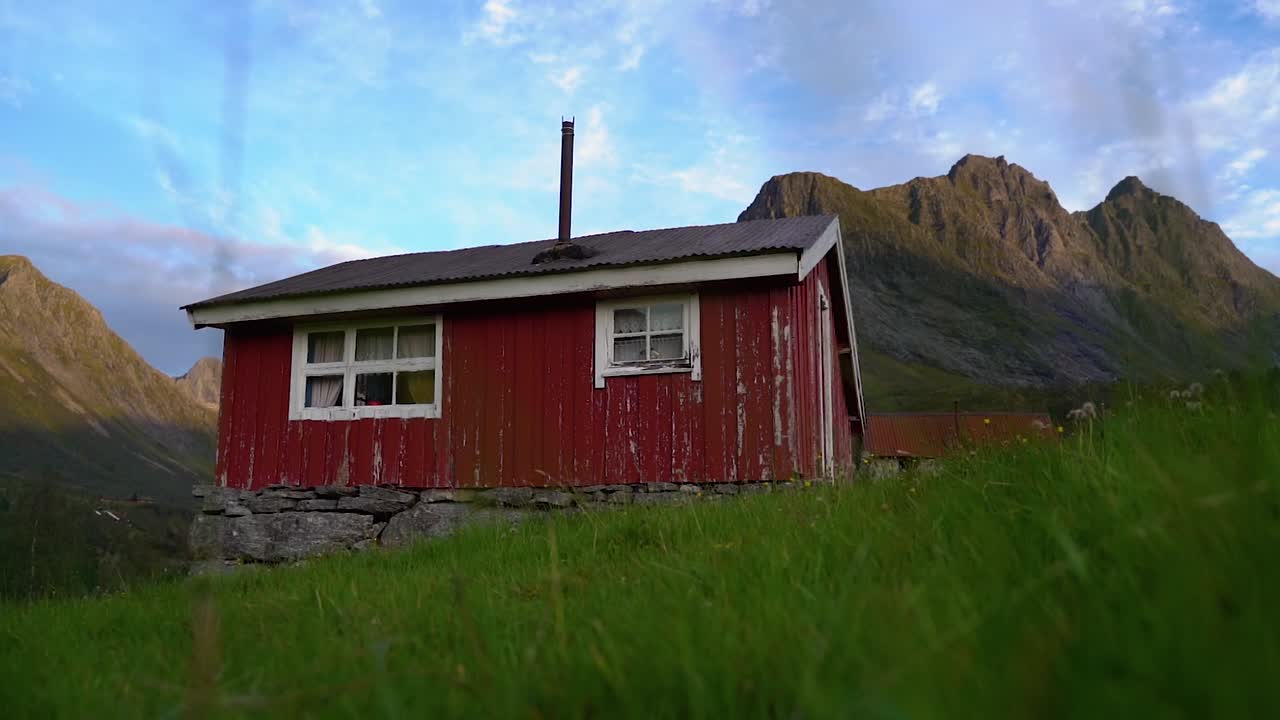 una pequeña casa roja en las montañas