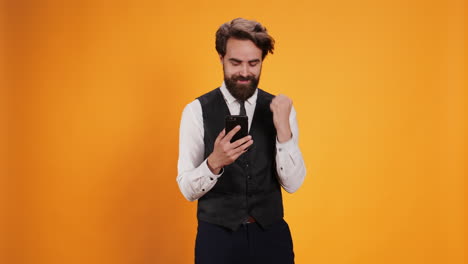 happy waiter reads news on phone