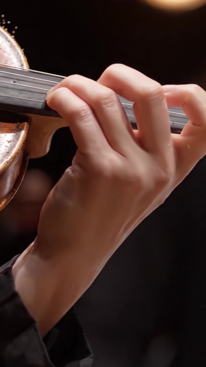 Captivating Close-Up of a Hand Playing the Violin, Showcasing the Instrument's Rich Texture and Masterful Technique in a Musical Performance Setting