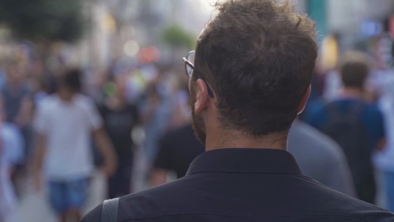 젊은이가 주변을 둘러보고 사람들 사이를  ⁇ 고 있습니다.