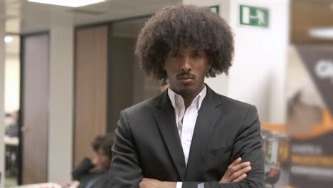 arrogant creative businessman standing with arms crossed in office