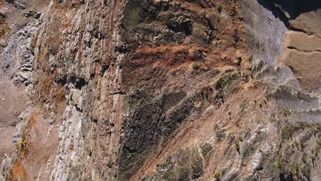 toma aérea de arriba hacia abajo siguiendo la cresta rocosa muy empinada