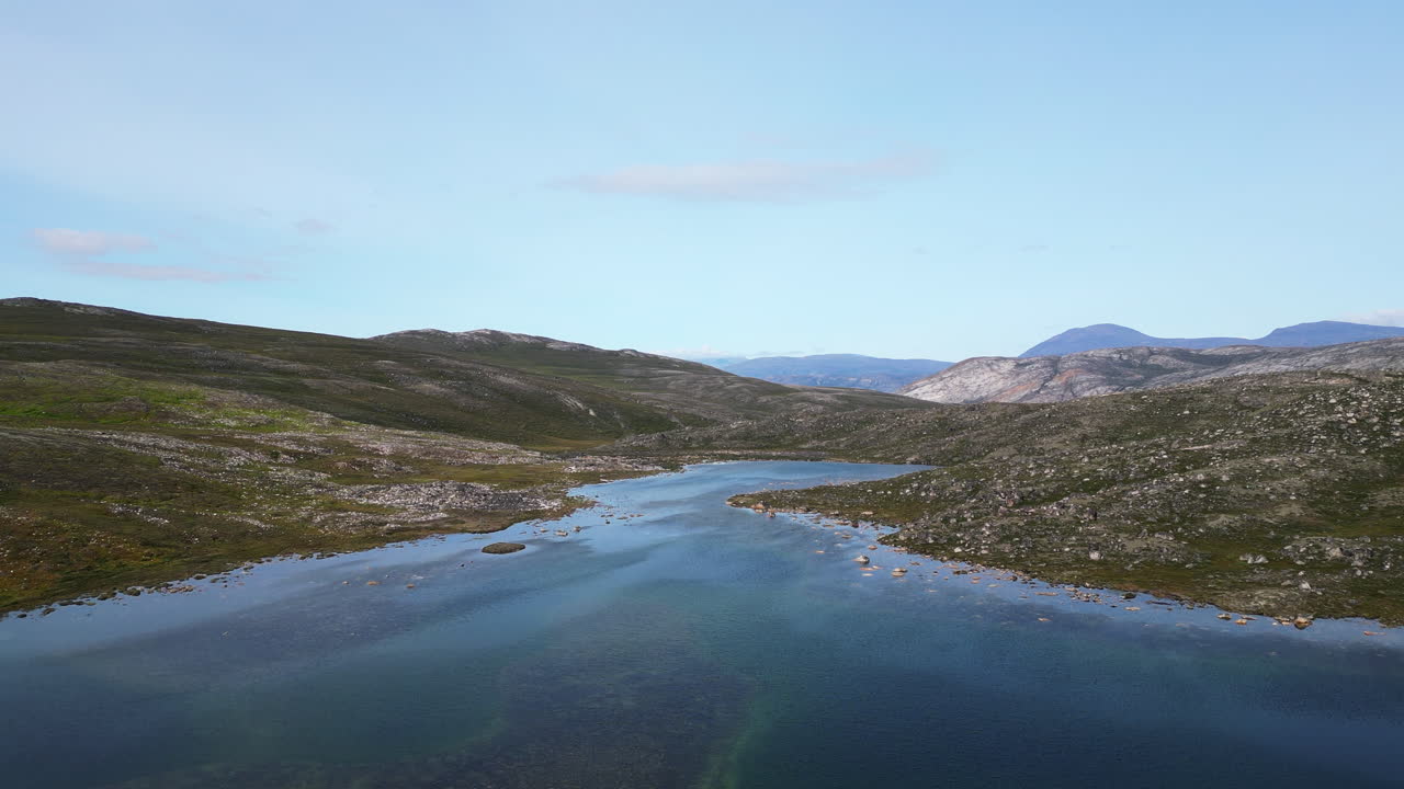 Aerial view rising above a lake in middle of raw tundra wilderness of Greenland
